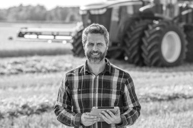 Tablet çekli İspanyol çiftçi. Ekin hasadı. Tarlada tableti olan çiftçi tarımcı adam. Modern tarımın teknolojisi. Tarlada tabletle çalışan çiftçi. Altın hasat alanları.