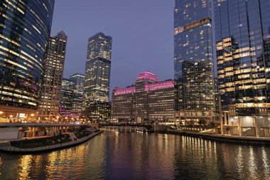 Nehirdeki Chicago gökdelenin mimarisi. Şehir gecesi aydınlatılmış bina. Gökdelen şehir manzarası. Chicago, Illinois 'de bir gece şehri. İş şehri. Chicago gökdelen binasının gece manzarası.
