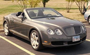Chicago, Illinois, ABD - 08 Eylül 2024: 2007 Bentley Continental GTC üstü açık araba, köşe manzaralı. Lüks gri bir araba. Bentley Continental GTC arabası. Chicago 'da metalik gri Bentley Continental GTC