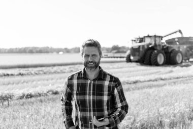 Tarlada tabletle çalışan çiftçi. Tablet çekli İspanyol çiftçi. Ekin hasadı. Tarlada tableti olan çiftçi tarımcı adam. Modern tarımın teknolojisi. Kırsal işçi.