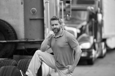 Kamyonun önünde yakışıklı bir şoför. Kamyon sahibi. Kamyon şoförü. Kamyon kamyonunun yanında bir erkek kamyon şoförü. Nakliye araçları. Yarı kamyon aracı. İspanyol kamyoncu adam. İhracat servisi.