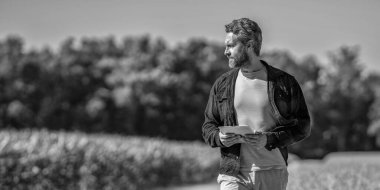 Çiftçi adam tabletle tarlada çalışıyor. Tablet çekli İspanyol çiftçi. Ekin hasadı. Mısır tarlasında tabletli çiftçi tarım uzmanı. Modern tarımın teknolojisi. Pankart reklamı.