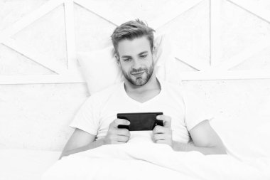 Hafta sonu milenyum adamı. Milenyum adamı evde akıllı telefon kullanırdı. Akıllı telefondan bahis oynayan adam. Video oyunu çevrimiçi. Telefonu izleyen adam. Yatak odasında bahis oynayan adam. Video çağrısı.