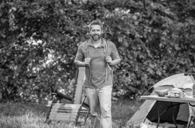 Yaz kampı ve doğa tatili. Yaz kampındaki adam. Kamp macerası. Yürüyüş konsepti. Kamp çadırı. Ormanda çadırlı sırt çantalı bir adam. Yaz günü doğa yürüyüşçüsü..