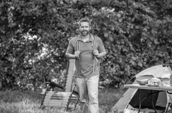 Yaz kampı ve doğa tatili. Yaz kampındaki adam. Kamp macerası. Yürüyüş konsepti. Kamp çadırı. Ormanda çadırlı sırt çantalı bir adam. Yaz günü doğa yürüyüşçüsü..