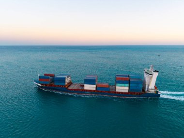 Konteyner gemisi. Nakliye lojistiği. Ticari nakliye. Kargo gemisi denizde, hava manzaralı. Yük konteynırı kargo gemisine yüklendi. Konteynırlı bir hava kargo gemisi. Kargo işi. Gemi kalkışı.