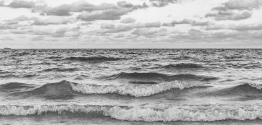 Deniz ufkuyla gökyüzü. Deniz doğarken sakin ufuk manzarası. Deniz manzarasında romantik yaz tatili gündoğumu. Deniz ufku manzarası. Yaz tatilinde bulutlu gökyüzü ve deniz manzarası. Deniz dalgaları.