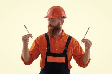 Sakallı marangoz çivi tutar. Marangoz, beyaz çiviyle tamir ediyor. Tamirci. Adam çekiç çivisi tutuyor. Marangozluk tamir ve çekiç. Tamircinin çivisi var..