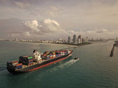 Kargo gemisinde nakliye konteynırı. Kargo gemisi limandan ayrılıyor. Konteyner gemisi. İhraç ve ithalat. Kargo işi. Miami Limanı. Konteynırlı gemi, hava manzaralı. Kargo tersanesi faaliyetleri.