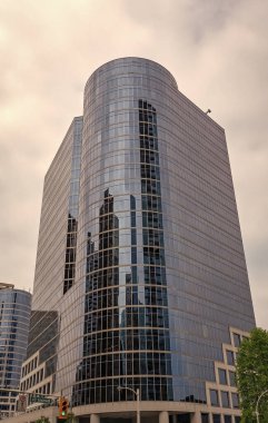 Gökdelen mimarisi. Camdan yapılmış bir gökdelen. Modern cam bina. Şehir merkezindeki gökdelen. Şehir hayatı. Şehir merkezinde gökdelenli. İş bölgesindeki ofis binası.