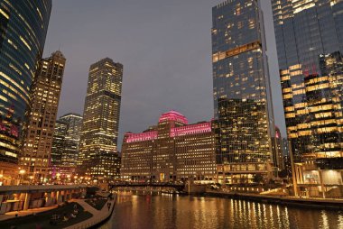 Nehirdeki Chicago gökdelenin mimarisi. Şehir gecesi aydınlatılmış bina. Gökdelen şehir manzarası. Chicago, Illinois 'de bir gece şehri. İş şehri. Chicago gökdelen binasının gece manzarası.