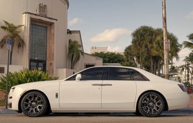 Miami, Florida, ABD - 12 Aralık 2024: Beyaz Rolls Royce Hayalet 2021 sedan araba. Rolls Royce Hayalet modelinin lüks sedan arabası. Rolls Royce 'un arabası dışarıda park edilmiş. Rolls Royce, yan görüş..