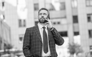 Ofis binasında telefonu olan İspanyol bir iş adamı. Telefon kullanan bir iş adamı. Şehirdeki erkek telefon konuşmaları. İş adamı telefonda konuşuyor. İş adamı işveren ön ofiste. Sosyal ağ.