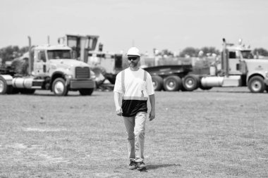 İspanyol işçi inşaatçısı başarılı bir adam ya da inşaat alanında miğferiyle yürüyen inşaat mühendisi..