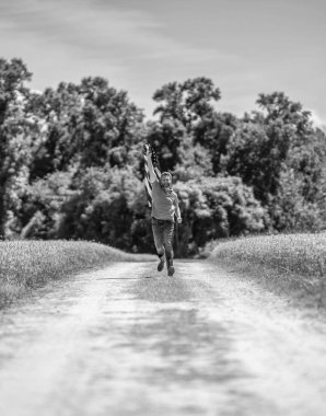 Bağımsızlık Günü. Sahadaki adam. Ekin tarlasında Amerikan bayrağı taşıyan adam. Amerika 'nın Bağımsızlık Günü. 4 Temmuz. Amerikan İşçi Bayramı. Amerikan bayrağı ve çiftçi adam. ABD bayrağı. Özgür ve mutlu.