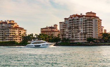 Fisher Adası Binası. Lüks motorlu tekne yatı. Yat marinaya gidiyor. Tekne ve yat gezisi. Lüks bir yaşam tarzı. Fisher Adası 'nda lüks bir binada yat. Yaz tatili. Romantik gün batımı.