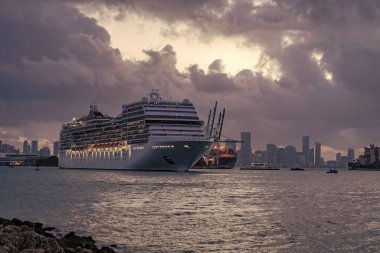Gemi seyahati. Yaz tatilindeki deniz yolculuğunun havadan görünüşü. Gemi turu ve deniz seyahati. Gece vakti ışıltılı lüks yolcu gemisi yolculuğunun havadan görünüşü. Gemi Miami sahil limanından ayrılıyor. Manzaralı gezi.