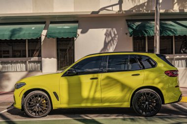 Miami, Florida, ABD - 11 Aralık 2024: BMW X5 2025 geçiş aracı. BMW X5 tipi lüks bir çapraz araba. BMW X5 'in arabası dışarıda park edilmiş. BMW X5 sarı renk, kenar görünüm.