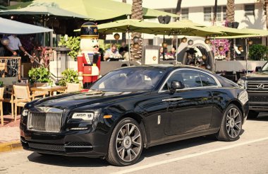 Miami, Florida, ABD - 09 Aralık 2024: 2018 Rolls Royce Wraith arabası. Rolls Royce Wraith 'in lüks arabası. Rolls Royce Wraith 'in arabası dışarıda park edilmiş. Rolls Royce Wraith, yan görünüm.