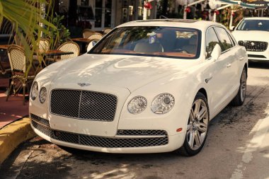 Miami, Florida, ABD - 17 Aralık 2024: 2016 Bentley Flying Spur Vur Sedan Car. Lüks araba beyaz Bentley Flying Spur V8 tipi. Bentley Uçan Mahmuz 'un arabası dışarıda park edilmiş. Bentley Uçan Mahmuz, köşe manzaralı..
