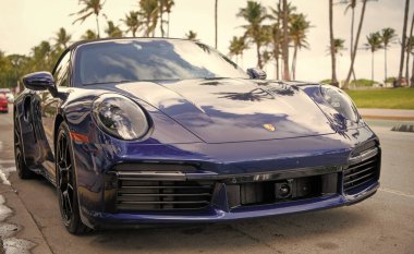 Miami, Florida, ABD - 15 Aralık 2024: Mavi Porsche 992 üstü açık spor araba. Üstü açık Porsche 992 model lüks spor araba. Porsche 992 'nin arabası dışarıda park edilmiş. Porsche 992, ön manzara..