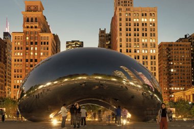 Chicago, Illinois, ABD - 22 Ekim 2024: Millennium Park ve ünlü Cloud Gate heykeli. Fasulye heykeli. Gökdelenli gece şehri manzarası. Chicago Milenyum Şehir Parkı. Bulut Kapısı.