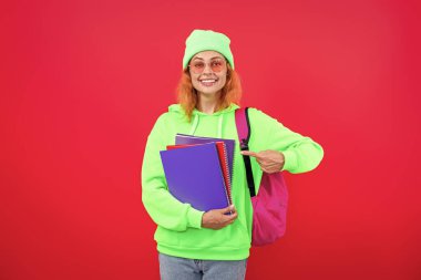 Okula dönelim. Bilgi toplama günü. Üniversitede eğitim. Pembe üzerine izole edilmiş genç bir kız. 1 Eylül. Bilgi ve eğitim. Okul eğitimi. Öğrenci hayatı. Üniversitedeki kız öğrenci. İşaret parmağı.