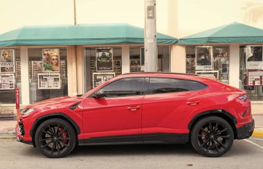 Miami, Florida, ABD - 15 Aralık 2024: kırmızı Lamborghini Urus 2022 çapraz otomobil. Lamborghini Urus tipi lüks bir arazi aracı. Lamborghini Urus 'un arabası dışarıda park edilmiş. Lamborghini Urus, yan görüş.