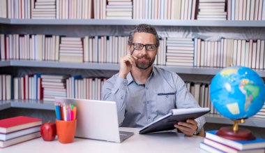 Okula dönüyorum. Kitapçıdaki akıllı öğretmen. Okul eğitimi. Öğretmenim okulda. İspanyol öğretmenle eğitim. Milenyel öğretmenlik eğitimi. Sınıfta ders veren adam. öğretmenler günü.