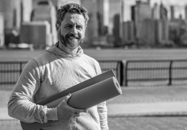 Yoga koçu. Sporcu adam antrenmana hazır. Sağlıklı bir yaşam tarzı. Spor ve spor. Eğitim için yoga minderi. New York 'ta sporcu. Manhattan 'da spor kıyafetli bir adam. Vücuduna uygun. Boşluğu kopyala.