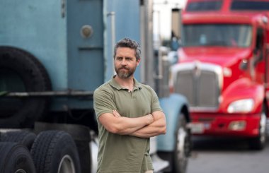 Kamyon şoförü. Kamyon kamyonunun yanında bir erkek kamyon şoförü. Nakliye araçları. Yarı kamyon aracı. İspanyol kamyoncu adam. Kamyonetin önündeki İspanyol şoför. Kamyon sahibi. Yol şöförü.