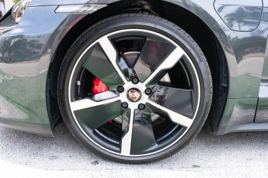 Miami, Florida, ABD - 12 Temmuz 2025: Porsche Taycan 2020 elektrikli araba. Lüks elektrikli Porsche Taycan. Porsche Taycan dışarıda park etmiş. Siyah elektrikli araba, tekerlek manzaralı..