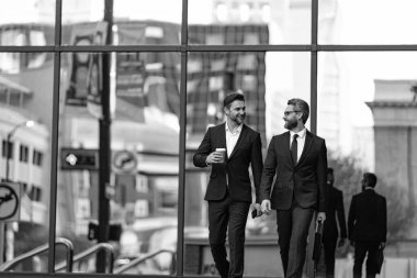 İş adamları işe gider. İş konuşuyoruz. Zarif takım elbiseli iki işadamı. Yürüyen meslektaşım. Meslektaşım ve arkadaşlarım. Dışarıda yürüyen iki başarılı iş adamı. İş bölgesi.