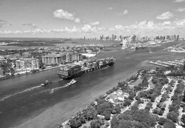 Miami, Florida, USA - June 07, 2024: Cargo ship in sea, aerial view. Freight container loaded on cargo vessel. Aerial view cargo ship entering port of Miami. Cargo business. Container ship. Shipping logistics. Commercial shipping.