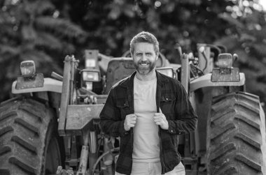 Tarım ekipmanları. Hasat makineli bir çiftçi. Traktörde olgun bir adam var. Traktör sürücüsü. Tarım alanında çalışıyorum. Çiftçi dışarıda traktörle tarlada. Ekin hasadı. Tarım için makine.