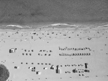 Yazın deniz kenarında tatil. Deniz, plaj şemsiyesi altında rahatlar. Denize açılın. Turkuaz suyla kumsalın havadan görünüşü. Lüks tatil köyü. Plaj güneşinin tadını çıkarıyorum. Yaz tatili. Egzotik yaşam tarzı.