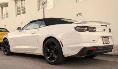 Miami, Florida, ABD - 15 Aralık 2024: Beyaz Chevrolet Camaro Chevy 2020 üstü açılır çift midilli arabası. Chevrolet Camaro 'nun üstü açık arabası. Chevy Camaro 'nun arabası dışarıda park edilmiş. Chevrolet Camaro, yan görüş..