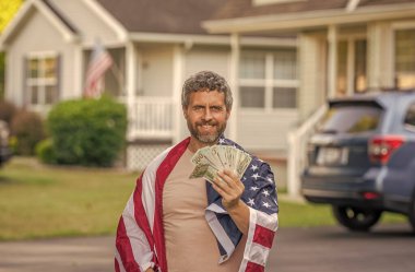 Amerikan bayrağı ve dolar parası olan adam. Enflasyon konsepti. Amerikan vergi politikası. İspanyol adam ve Amerikan bayrağı. Amerika 'da vergi ödemek. Katma değer vergisi. Vergi sistemi. ABD 'li vatandaşın geliri.