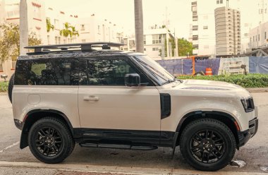 Miami, Florida, ABD - 08 Aralık 2024: 2023 Land Rover Defender SUV pikap kamyonu. Land Rover Defender 'ın lüks SUV arabası. Land Rover 'ın arabası dışarıda park edilmiş. Land Rover Defender, yan görünüm.