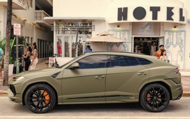Miami, Florida, ABD - 08 Aralık 2024: Luxur yeşil renkli Lamborghini Urus S tipi spor araba. Lamborghini Urus 'un arabası dışarıda park halinde. Lamborghini Urus, yan görüş. 2024 Lamborghini Urus S SUV arabası.