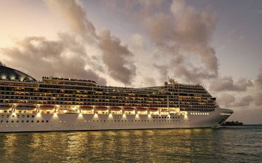 Gemi seyahati. Yaz tatilindeki deniz yolculuğunun havadan görünüşü. Gemi turu ve deniz seyahati. Gece vakti ışıltılı lüks yolcu gemisi yolculuğunun havadan görünüşü. Gemi Miami sahil limanından ayrılıyor. Manzaralı gezi.