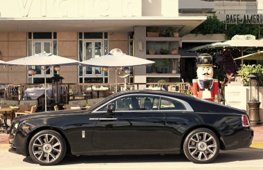 Miami, Florida, ABD - 09 Aralık 2024: siyah 2018 Rolls Royce Wraith arabası. Rolls Royce Wraith 'in lüks arabası. Rolls Royce Wraith 'in arabası dışarıda park edilmiş. Rolls Royce Wraith, yan görünüm.