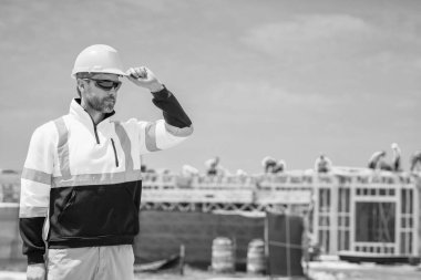 İnşaat mühendisi inşaat alanında. Denetmen mühendis. İnşaat işçisi. İnşaat müdürü. İnşaatçı adam. Kasklı bir işçi. İnşaatta sanayi işçisi. Reklam pankartı.