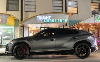 Miami, Florida, ABD - 8 Nisan 2025: lüks turuncu SUV araba Lamborghini Urus. Lamborghini Urus 'un arabası dışarı park edilmiş, köşe manzaralı. Lamborghini Urus 2021 lüks SUV Gri Matt rengi.