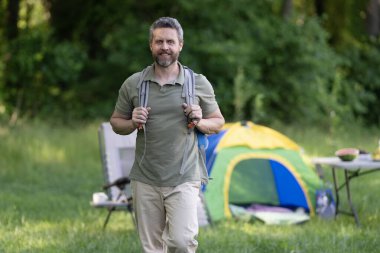 Ormanda yürüyüş yapan sırt çantalı bir yürüyüşçü. Ormandaki çadırda erkek yürüyüşçü. Sırt çantalı bir gezgin. Yürüyüş macerası. Seyahat yaşam tarzı. Kırsalda yürüyüş yapan bir adam. Ormandaki İspanyol adam..