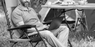 İş sırasında piknik yapan bir adam, kırpılmış bir manzara. Yaz kampı. Kampta dizüstü bilgisayarda daktilo yazan bir iş adamı. İnternette çalışan bir iş adamı. Serbest çalışan bir iş adamı. İş adamı çalışıyor.