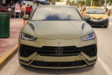 Miami, Florida, ABD - 08 Aralık 2024: Luxur yeşil renkli Lamborghini Urus S tipi spor araba. Lamborghini Urus 'un arabası dışarıda park halinde. Lamborghini Urus, köşe manzaralı. 2024 Lamborghini Urus S SUV arabası.