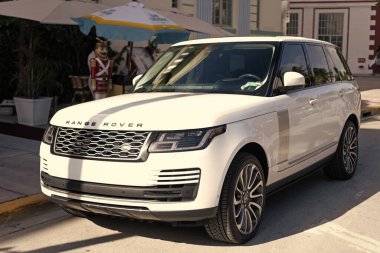 Miami, Florida, ABD - 17 Aralık 2024: Land Rover Range 2018 geçiş aracı. Land Rover 'ın lüks aracı. Beyaz araba Range Rover 'ı dışarıda park etmiş, köşe manzaralı.