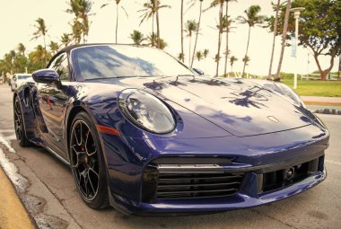Miami, Florida, ABD - 15 Aralık 2024: Mavi Porsche 992 üstü açık spor araba. Üstü açık Porsche 992 model lüks spor araba. Porsche 992 'nin arabası dışarıda park edilmiş. Porsche 992, ön manzara..