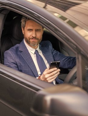 Başarılı bir araba satıcısı. Satış. Takım elbiseli bir adam arabada telefon kullanıyor. Telefonu olan İspanyol bir işadamı. Başarılı bir bayilik. İş adamının telefonu var. Araba sigortası. Şirket şoförü..
